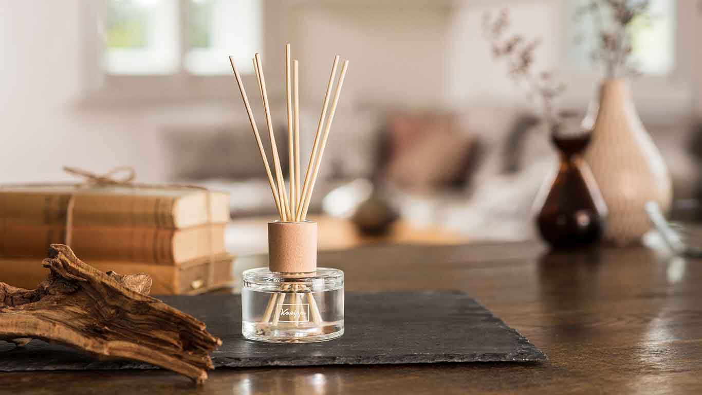 Kneipp Duftstäbchen auf Schiefertafel in gemütlichem Ambiente eines Wohnzimmers.