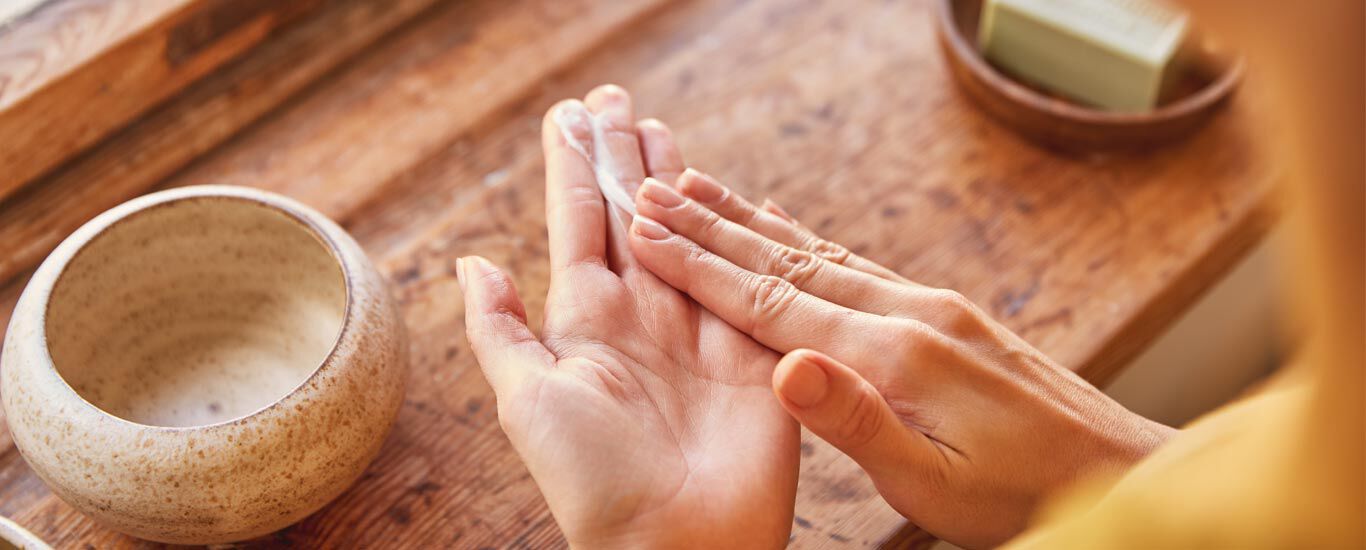 Nahaufnahme von Händen mit Handcreme. 