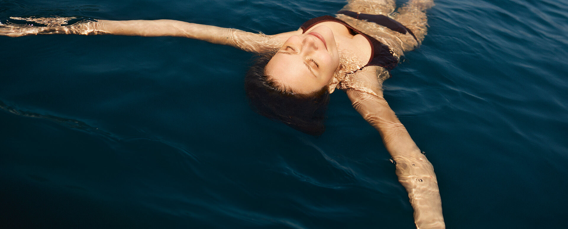Frau floatet im Wasser.