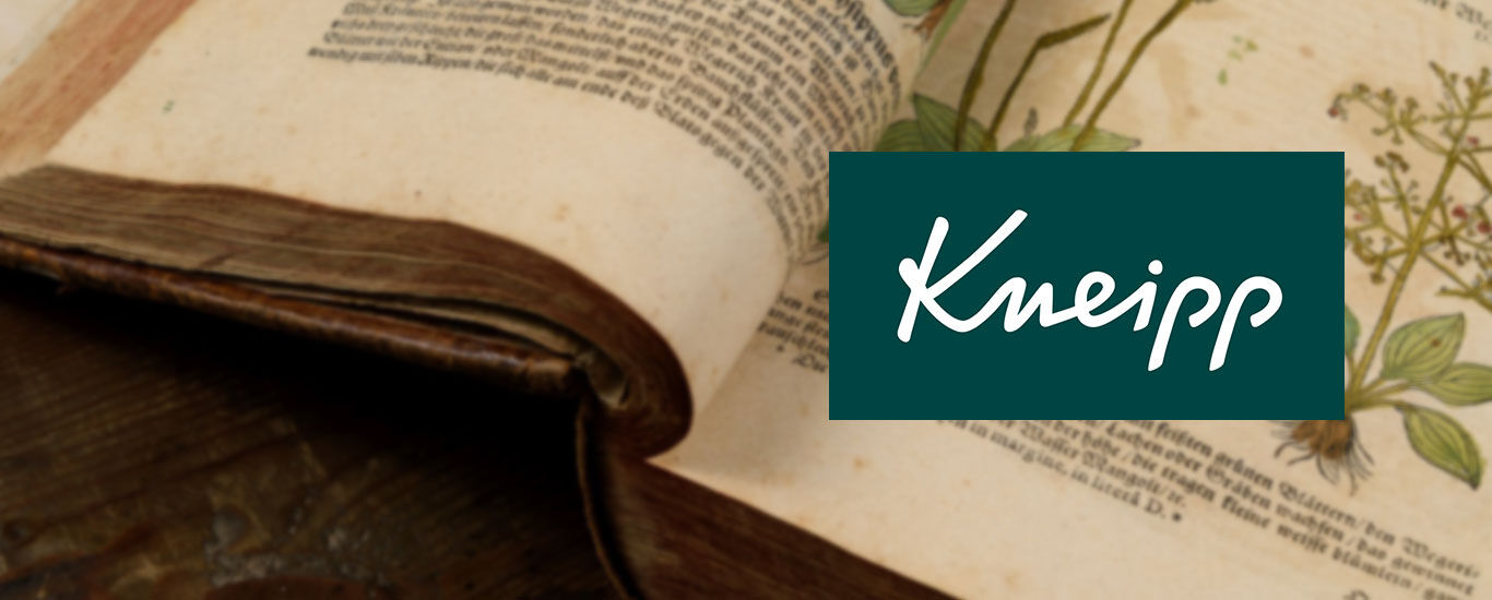 Aufgeschlagenes, historisches Buch, darauf Kneipp Logo. 