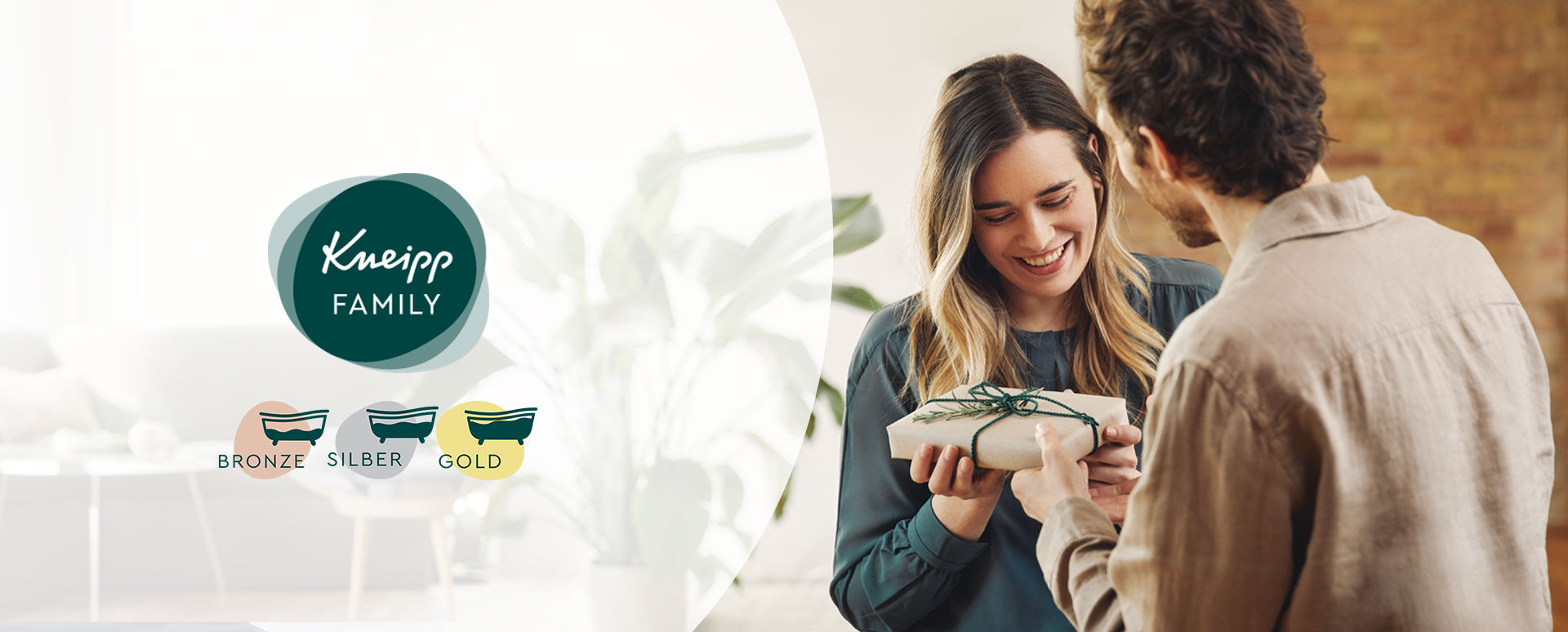 Feiere mit uns 15 Jahre Kneipp Family Mann übergibt einer Frau ein Geschenk, Kneipp Family Logo mit Status Icons Bronze, Silber, Gold