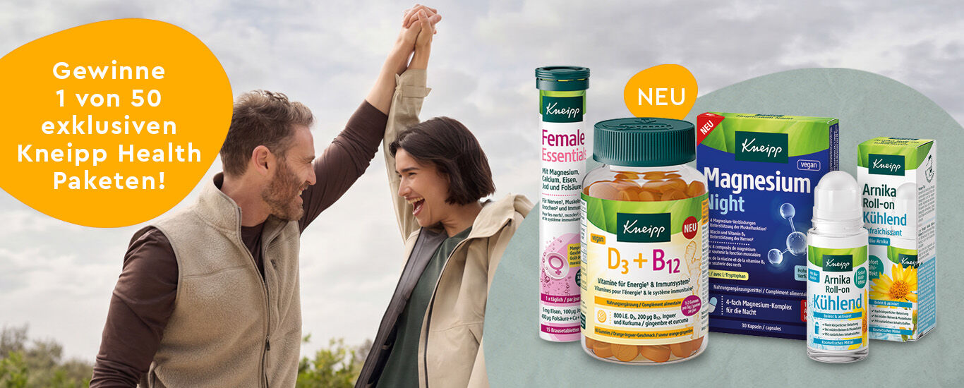 L&auml;chelnde Frau die an einer weissen Bl&uuml;te riecht.