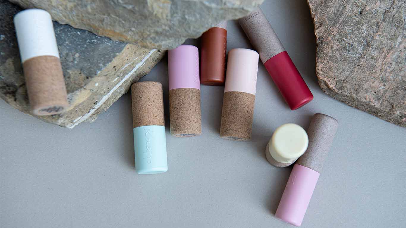 Kneipp Lippenpflegen auf einen grauen Tisch mit grauen Steinen.