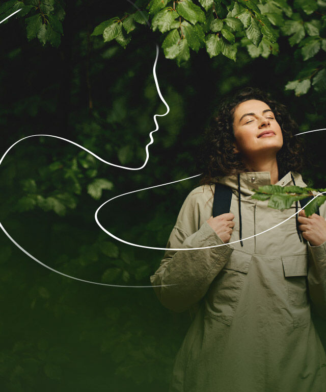 Frau schaut im Wald und in den Himmel und genie&szlig;t die Natur. Eine wei&szlig;e Illustration als Linie durchzieht das Bild und symbolisiert ein Frauengesicht im Profil.
