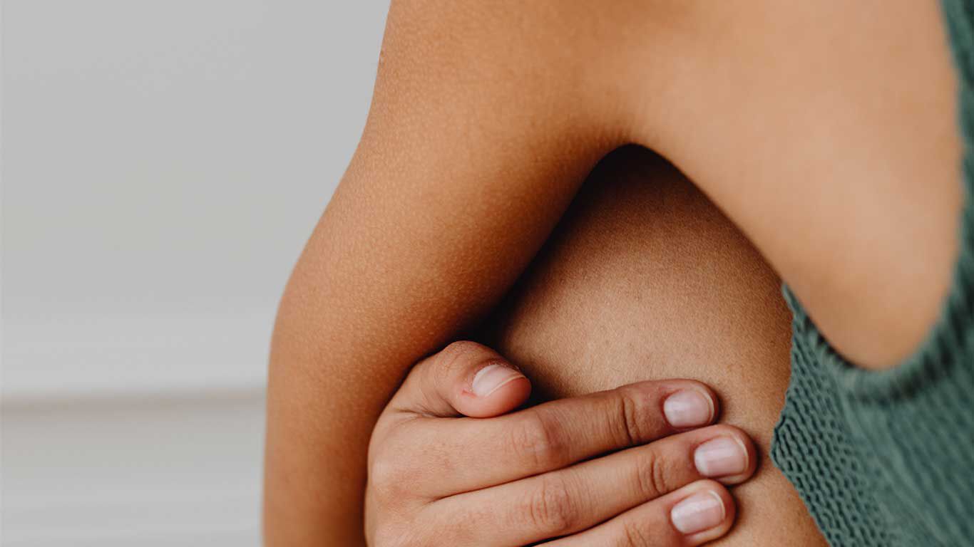 Gros plan sur une femme en maillot de bain vert, assise.