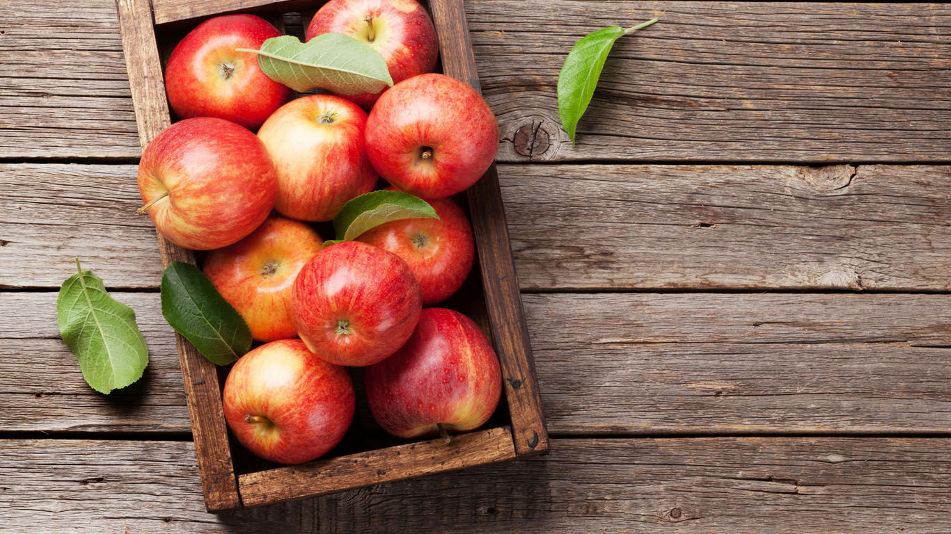 Des pommes rouges dans une caisse en bois.