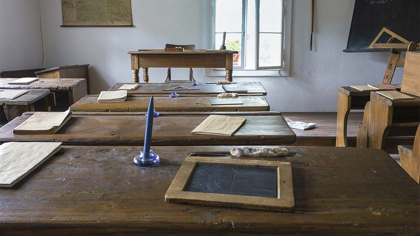 Salle de classe historique avec des bancs d'école.