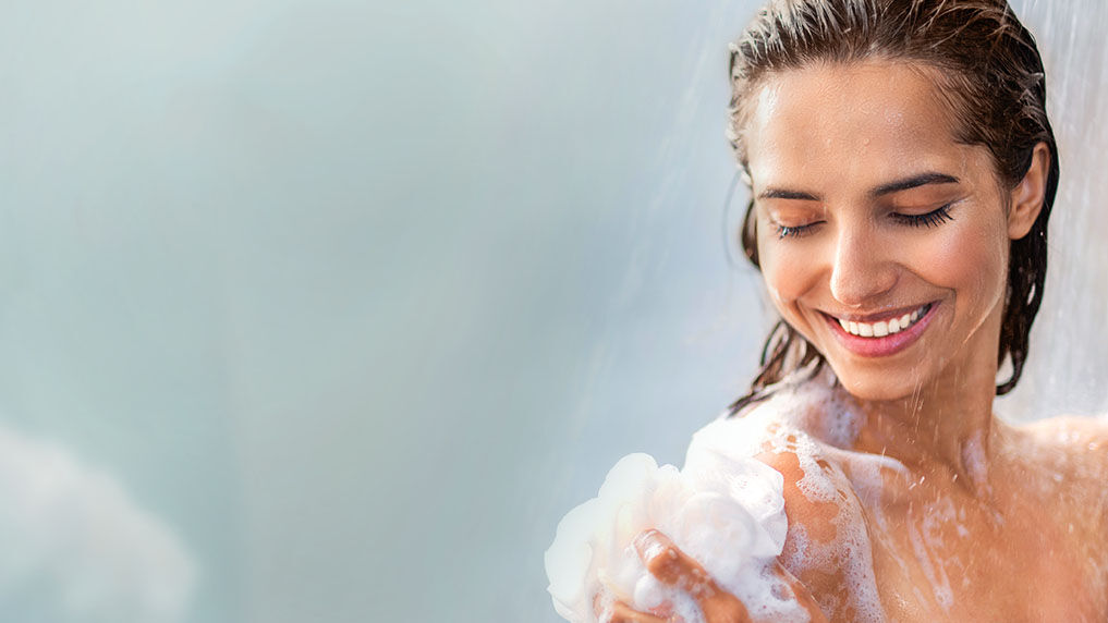 Une femme se fait mousser avec de la mousse de douche. 