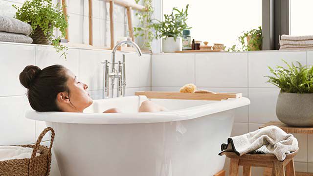 Une femme est allongée dans la baignoire et se détend.
