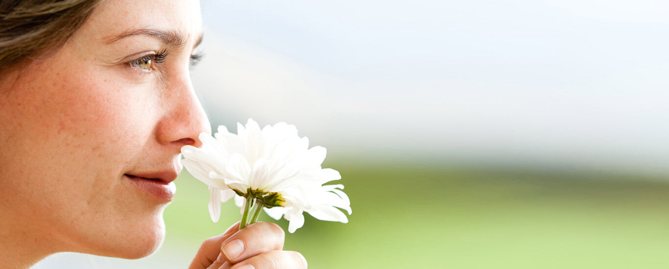  Une femme sent une fleur.