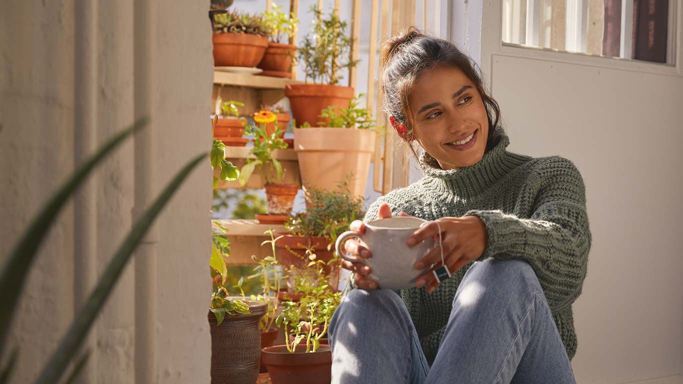 Une femme se réjouit de ses herbes de balcon.