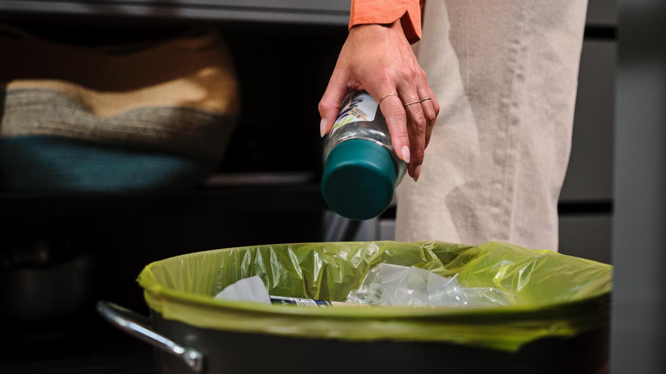 Une personne jette un produit Kneipp dans un sac jaune.