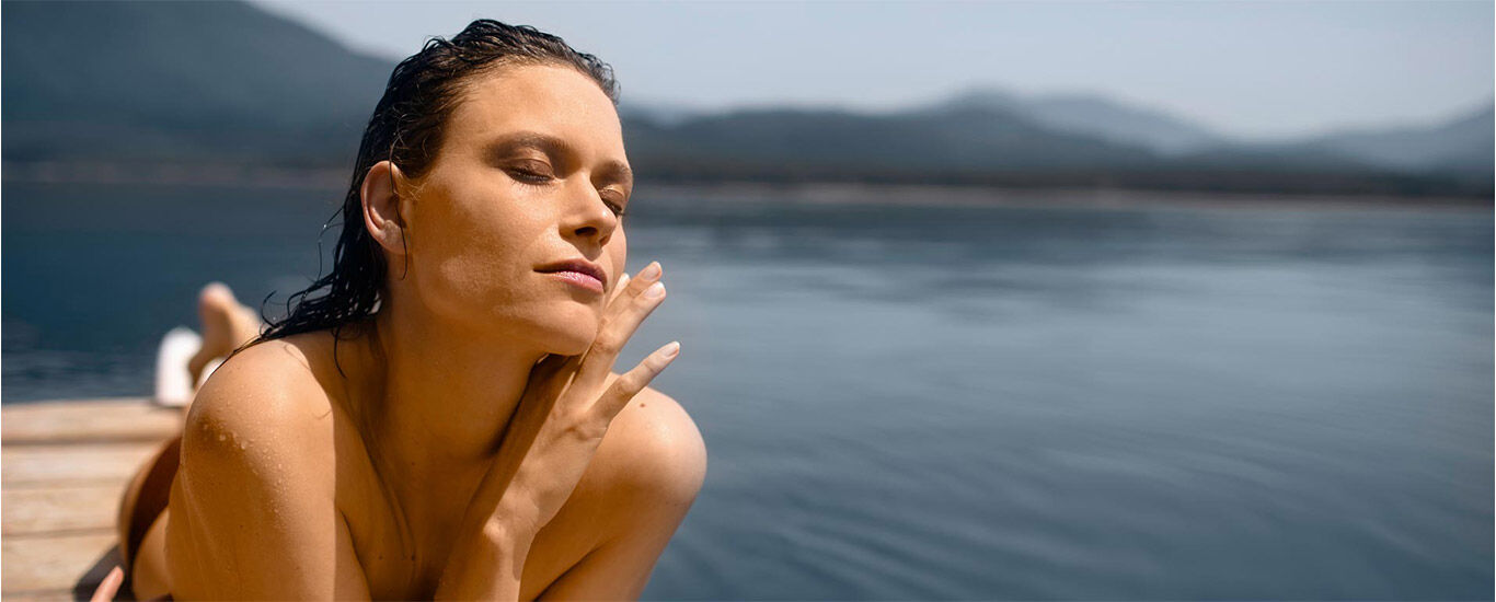 Une femme se détend au soleil sur un ponton.