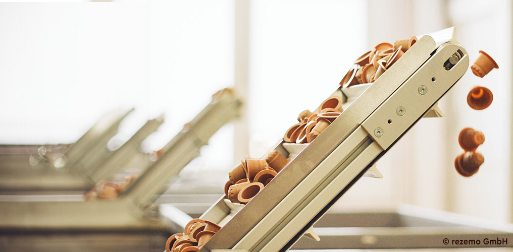 K&aacute;vov&eacute; kapsle vyroben&eacute; z dřevěn&yacute;ch vl&aacute;ken se pohybuj&iacute; po dopravn&iacute;m p&aacute;su