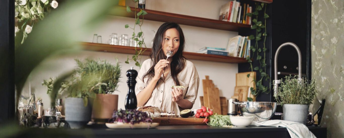 Mujer cocinando y probando la comida