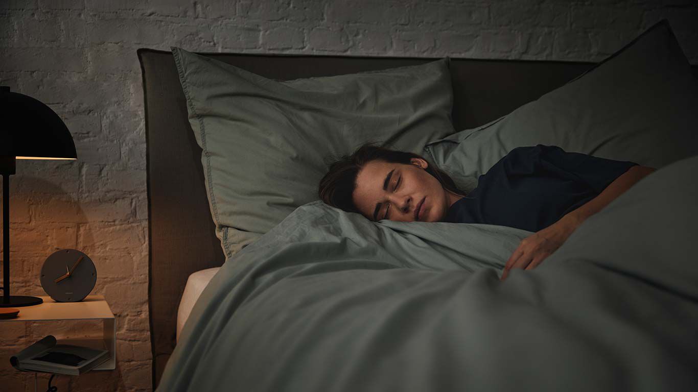 Une femme dort dans son lit.