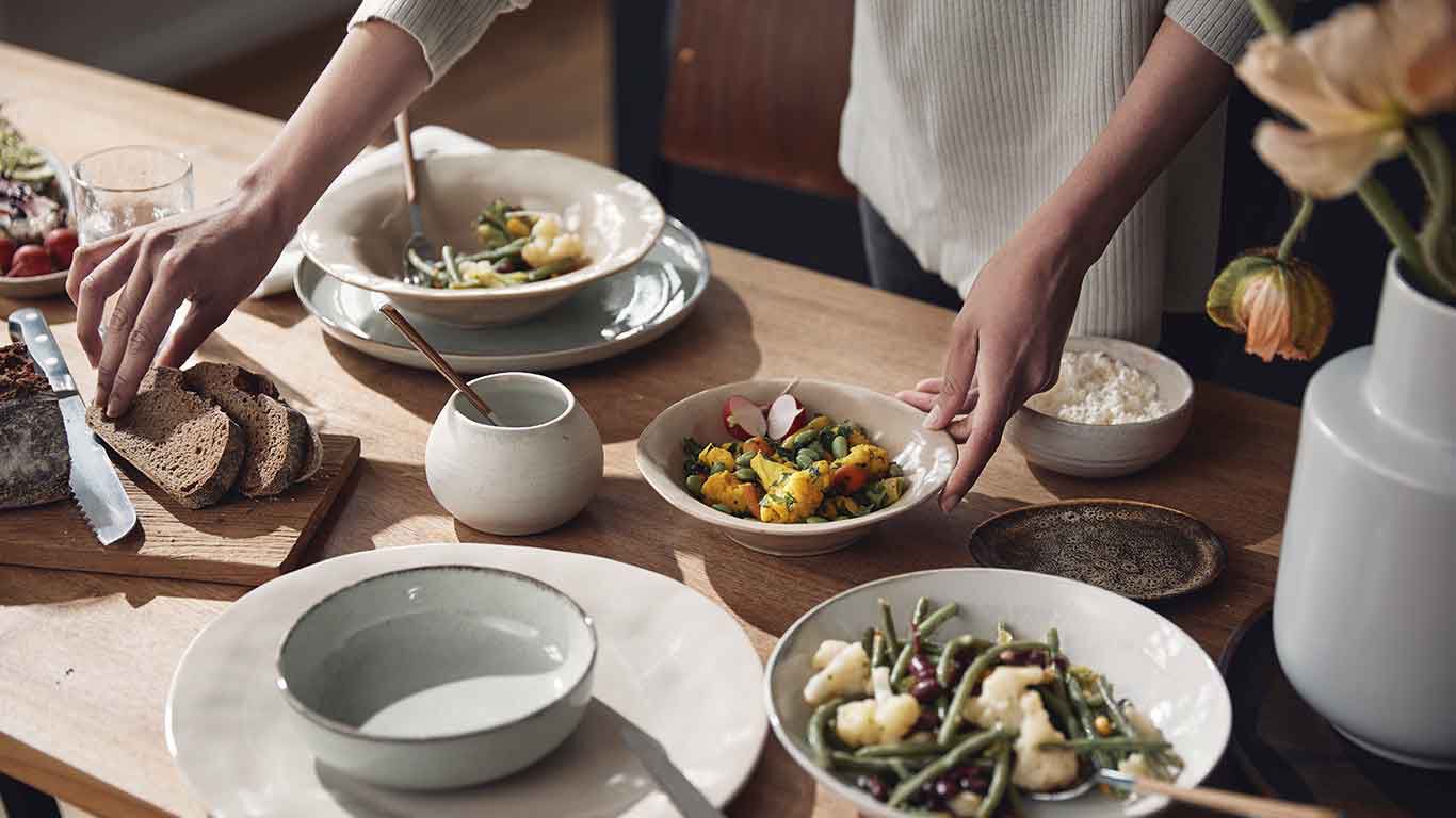 Des bols de plats de légumes frais sur une table en bois.