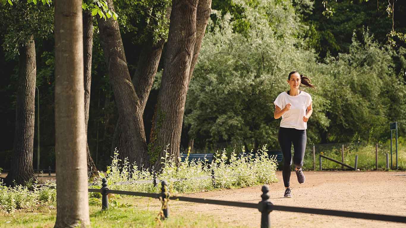 Une femme fait son jogging dans le parc.