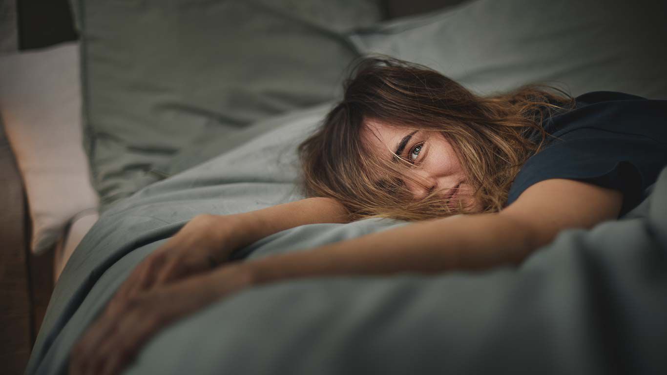 Une femme est réveillée dans son lit.