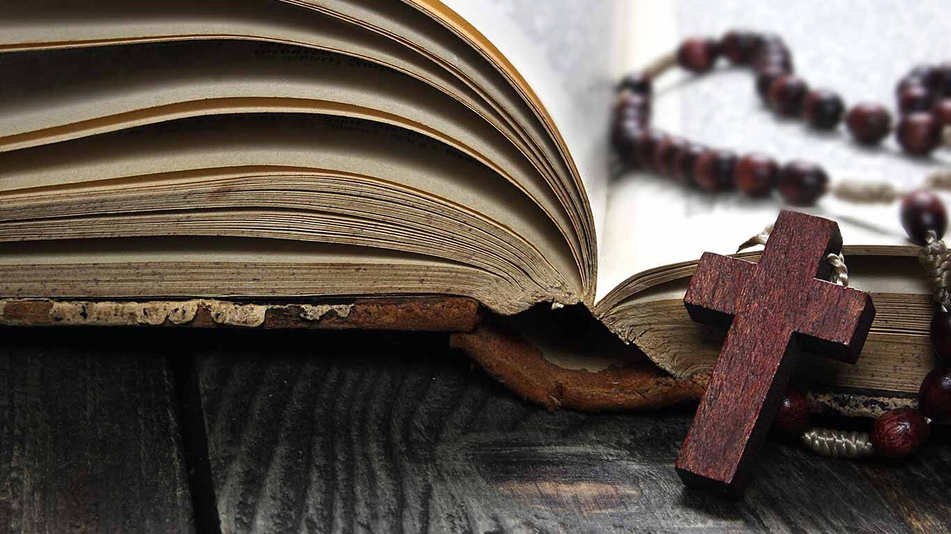 Rosary lies on an open book.