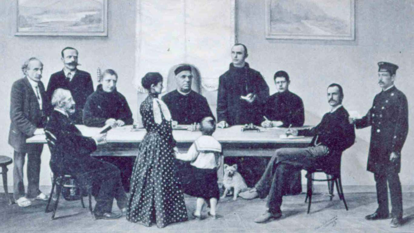 Pastor Sebastian Kneipp z ludźmi zgromadzonymi wokół dużego stołu.